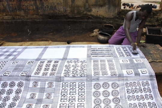 Anthony Boakye prints an adinkra cloth with a calabash stamp in Ntonso, Ghana. "NtonsoAdinkra" by ArtProf - Own work. Licensed under CC BY-SA 3.0 via Commons - https://commons.wikimedia.org/wiki/File:NtonsoAdinkra.jpg#/media/File:NtonsoAdinkra.jpg
